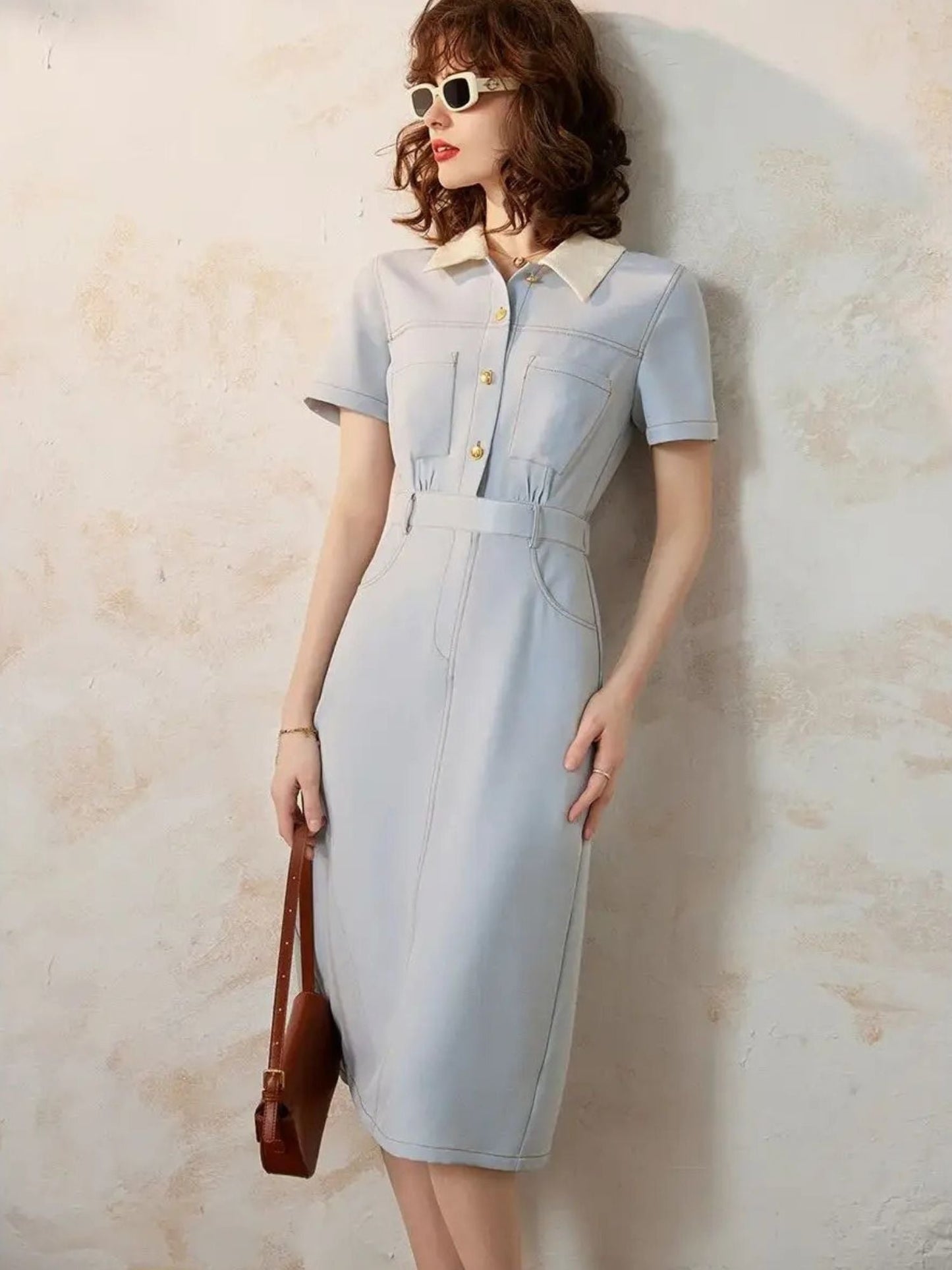 Model in light blue short-sleeve midi dress with contrast collar and sunglasses.