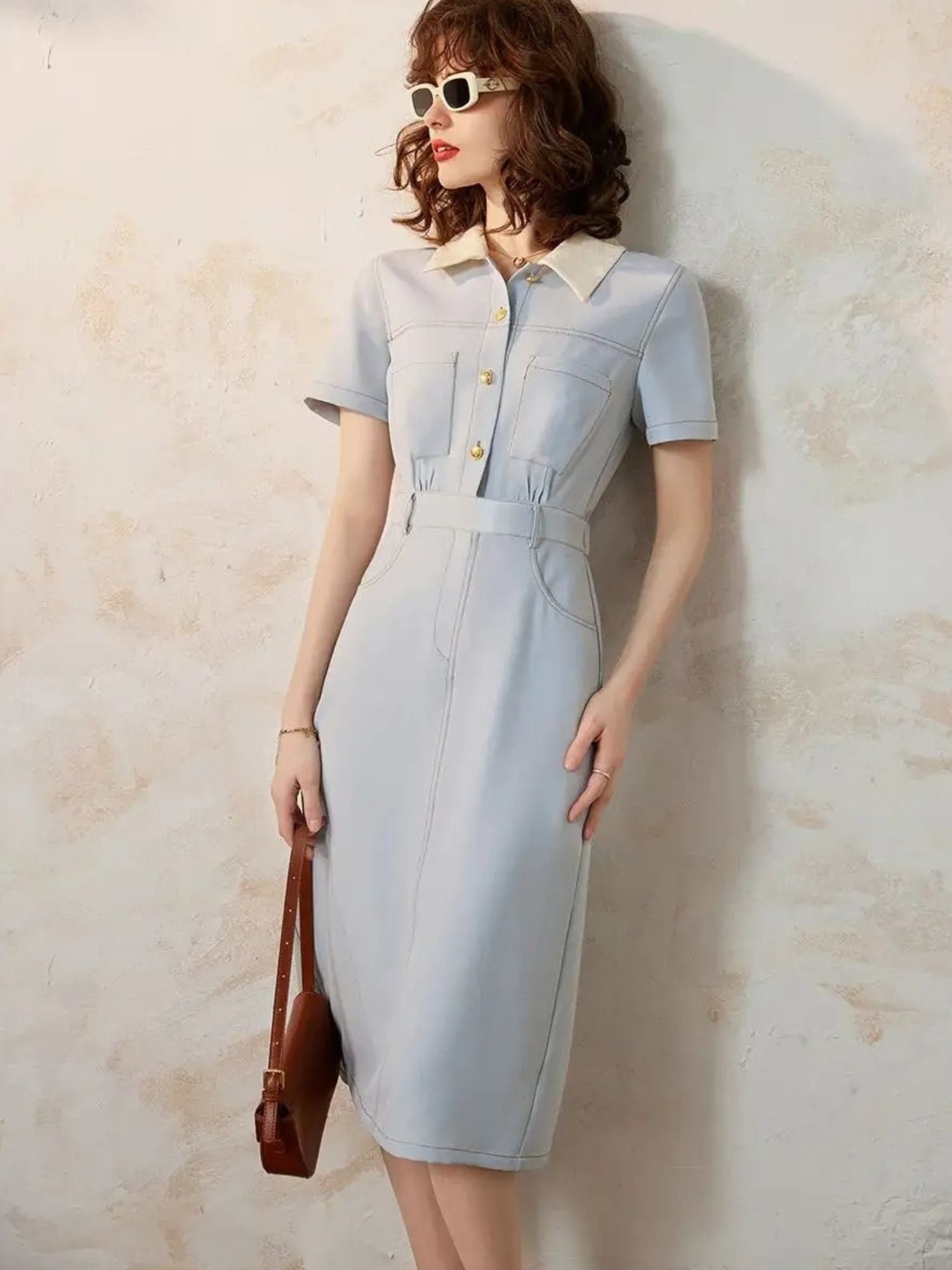 Model in light blue short-sleeve midi dress with contrast collar and sunglasses.