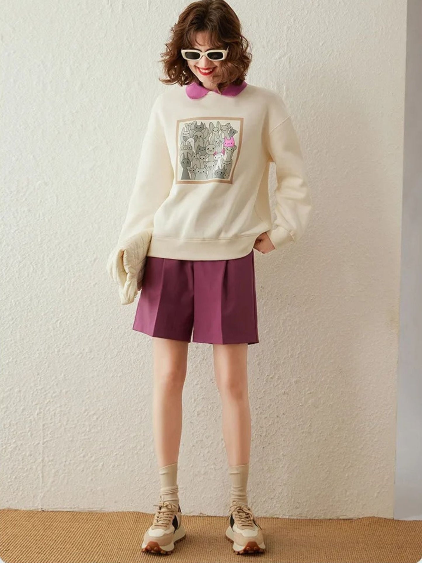 Full-body view of cream printed sweatshirt with pink skirt and heels.