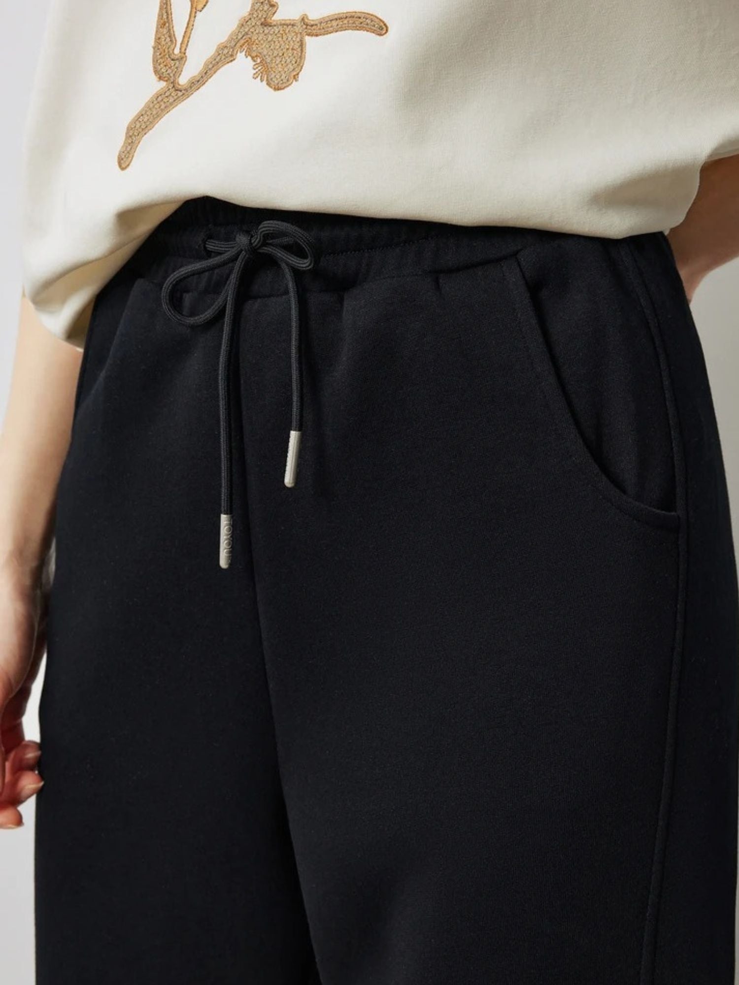 Close-up of black drawstring waistband with side pocket detail.