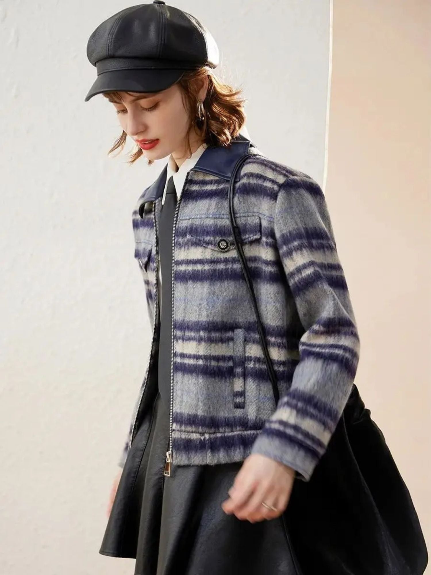 Side view of purple plaid jacket with flap pockets, paired with white blouse and black skirt.