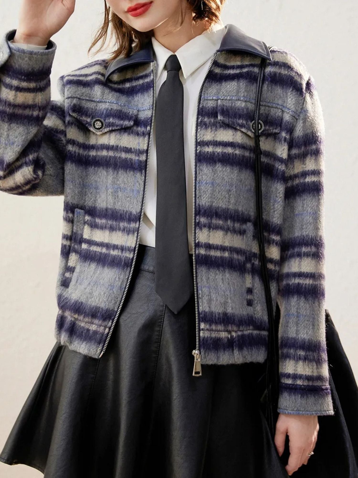 Close-up front view of plaid zip-up jacket with subtle fringe hem, worn over a white shirt.