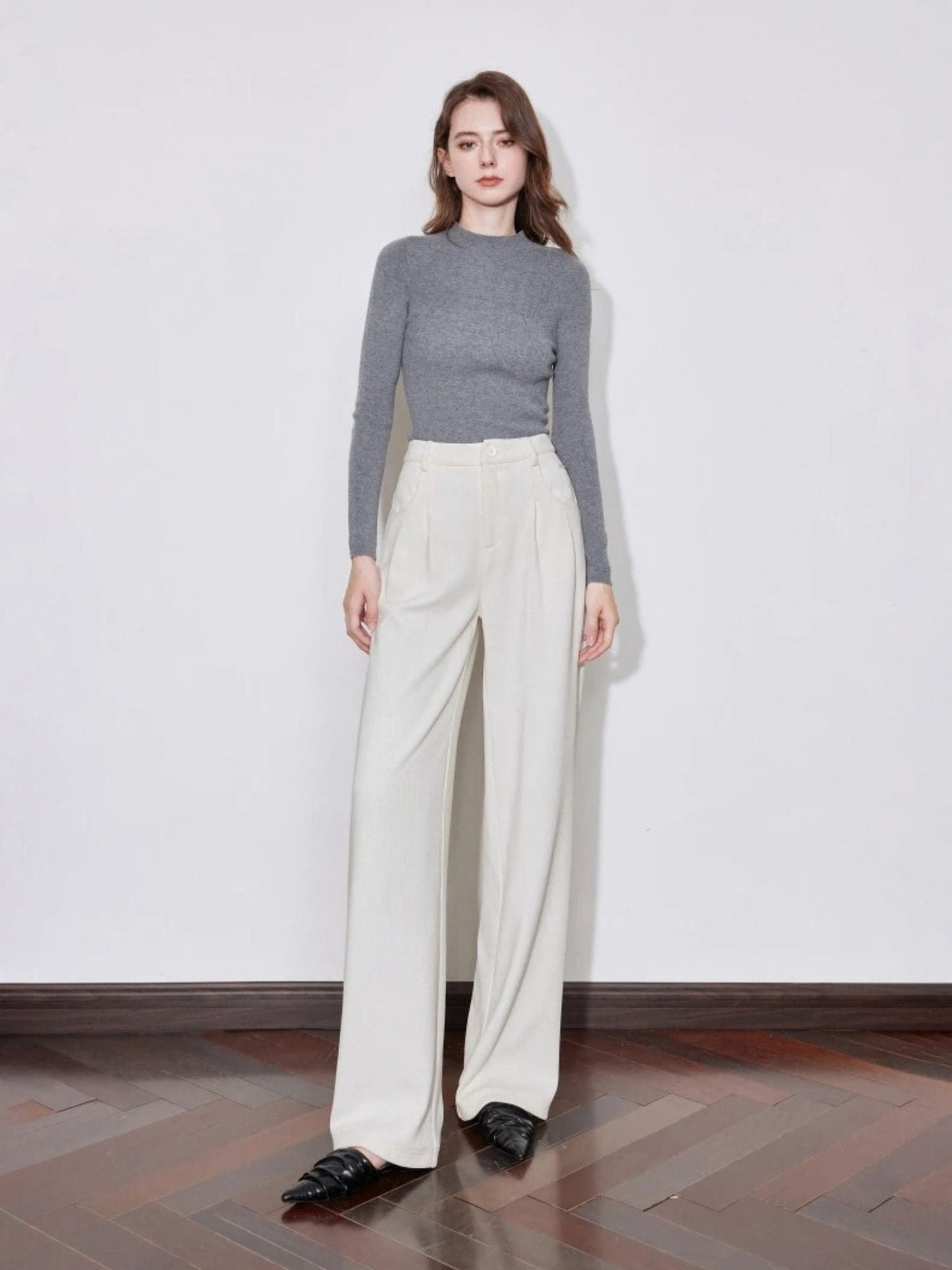 Model wearing cream wide-leg trousers with grey ribbed top and loafers.