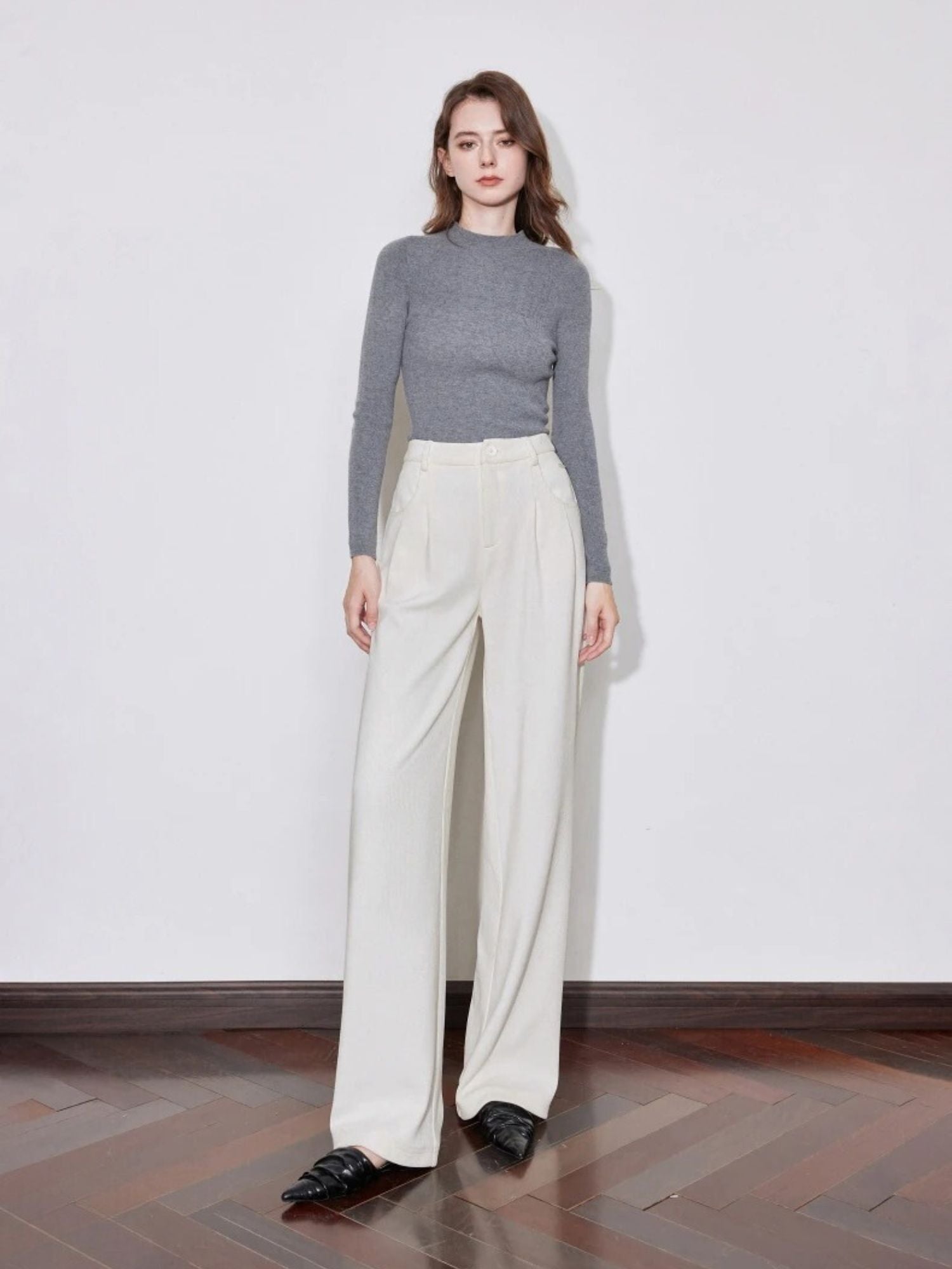 Model wearing cream wide-leg trousers with grey ribbed top and loafers.