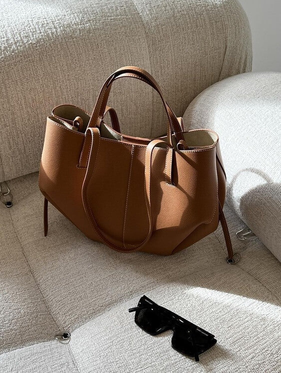 Braun ledertasche auf einem sofa
